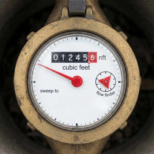 Close-up of a residential water meter showing the leak indicator triangle for detecting silent plumbing leaks.